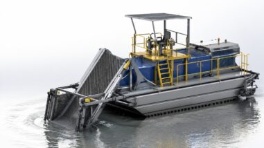Amphibious weed harvester collecting aquatic vegetation from a lake and wetland area
