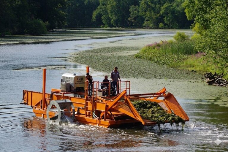 Aquatic weed harvester collecting floating vegetation from a lake surface